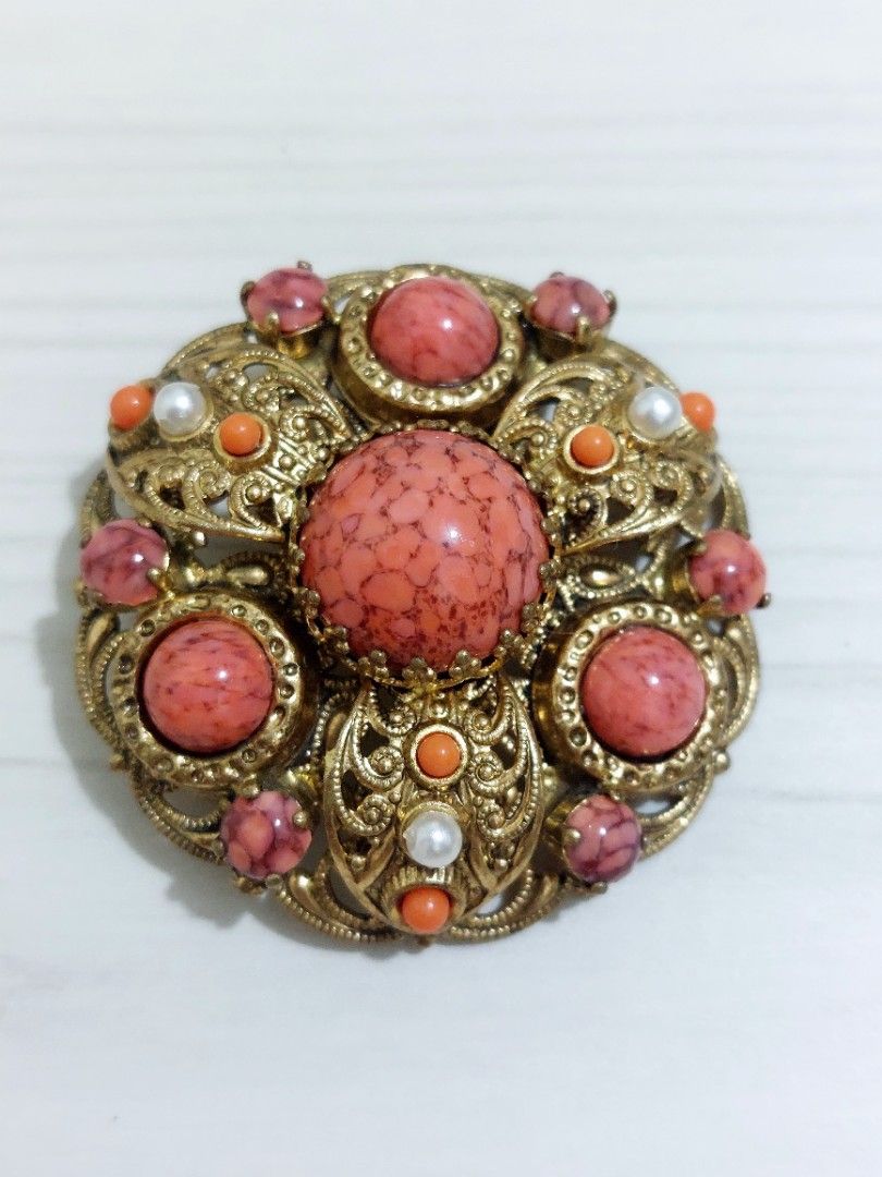 Vtg Brass Filigree Brooch (Category: Luxury Accessories) located in Muntinlupa City. Submitted by sakurambo_des (Listing ID 1466079156, Image 1). Description: Vintage Brass Filigree Brooch featuring speckled coral-colored art glass cabochons and simulated pearl accents, commonly associated with mid-century in West Germany. Check pictures for measurement. In very good condition..