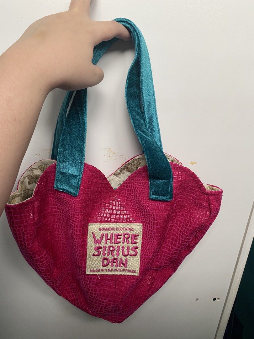 Where Sirius Dan Pink Heart Bag (Category: Shoulder Bags) located in Quezon City. Submitted by jeno_is_moving (Listing ID 1466000763, Image 1). Description: - Style: Bright pink faux snakeskin heart-shaped silhouette - Straps: Contrast teal blue velvet - Interior: Gold and white patterned fabric lining with an open pocket - Brand: Where Sirius Dan Nomadic Clothing Got it at Purveyr Fair! Used only once No flaws or any issues! Original price: P340