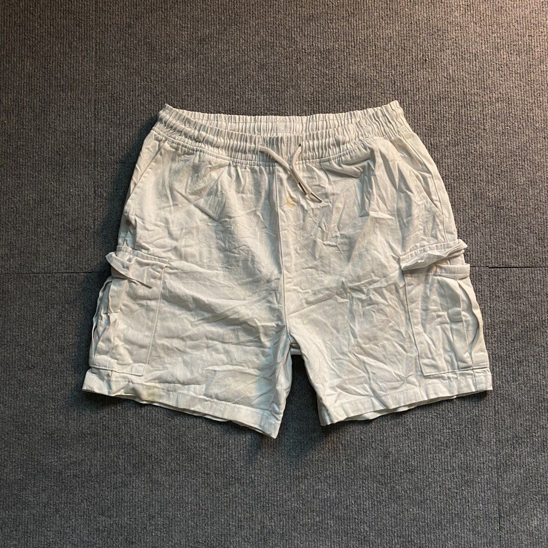 White Cargo Shorts with Drawstring and Pockets (Category: Shorts) located in Malaybalay. Submitted by mat.loots (Listing ID 1466088062, Image 1). Description: - Color: White - Material: Lightweight, perfect for warm weather - Waistband: Elastic with matching drawstring - Pockets: Two side utility pockets with flaps - Style: Casual - Flaws: A couple of visible yellow stains near the front center and bottom left leg - Condition: Still has plenty of