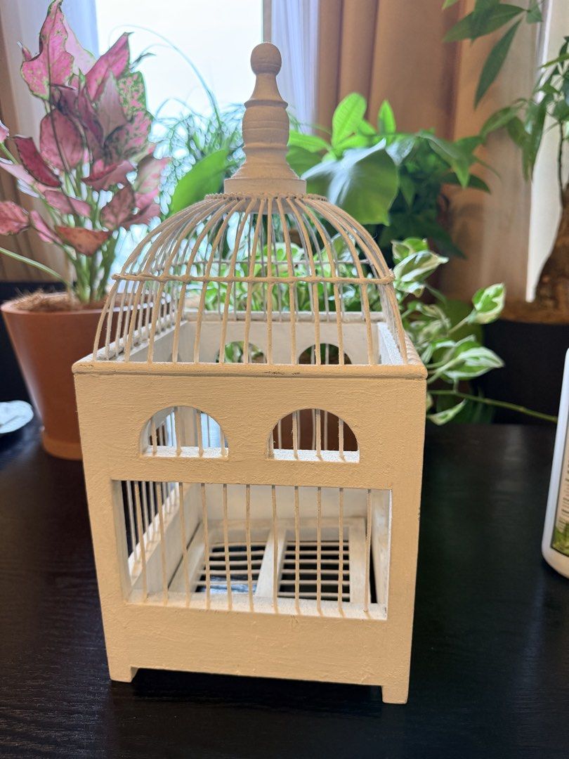 White Decorative Birdcage Home Decor Accent (Category: Vases & Decorative Bowls) located in Quezon City. Submitted by yourheaduhunter (Listing ID 1466098639, Image 1). Description: - Color: White with wooden base - Material: Metal wire dome top and solid construction - Design: Square shape with arched window details and four small feet - Versatility: Great accent piece for shelves, tabletops, or floral displays - Condition: Solid and painted fini
