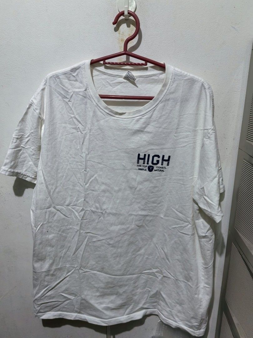 White HIGH Graphic T-Shirt (Category: Shirts) located in Quezon City. Submitted by jasalexiz (Listing ID 1466107612, Image 1). Description: - Color: White - Material: Soft, comfortable cotton - Design: Small dark blue graphic print on chest with shield logo - Cut: Crew neck, short sleeves, relaxed casual fit - Condition: Brand new with standard collar tag - Perfect for daily casual wear.
