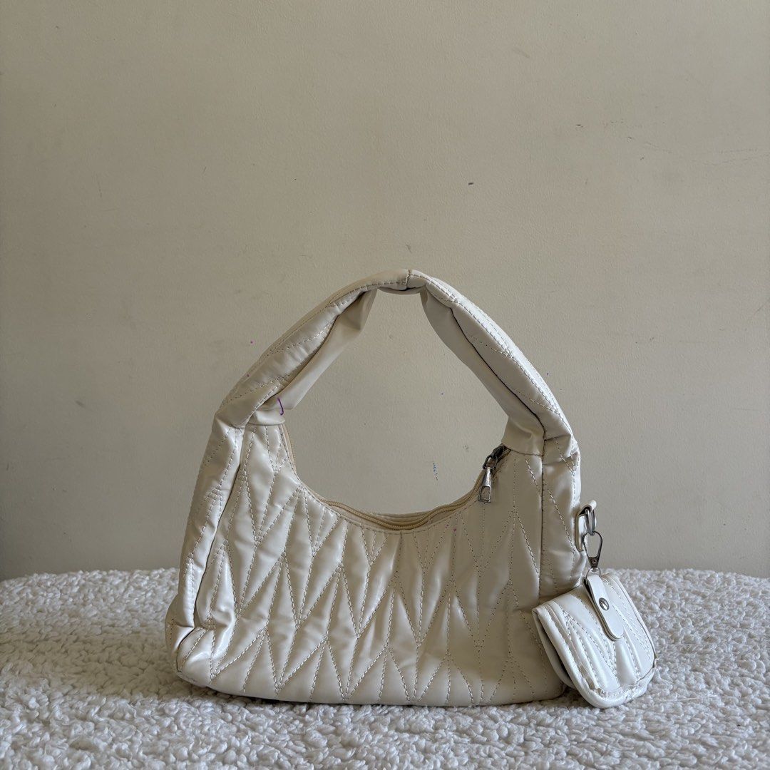 White Quilted Shoulder Bag with Pouch (Category: Shoulder Bags) located in Calabanga. Submitted by vrncashane (Listing ID 1466113913, Image 1). Description: - Color: White - Design: All-over chevron quilt stitching with a soft, slouchy shape - Closure: Zip top with sleek silver hardware - Extra: Matching mini coin pouch that clips onto the side ring - Comfort: Easy-to-wear handle drop for daily use.
