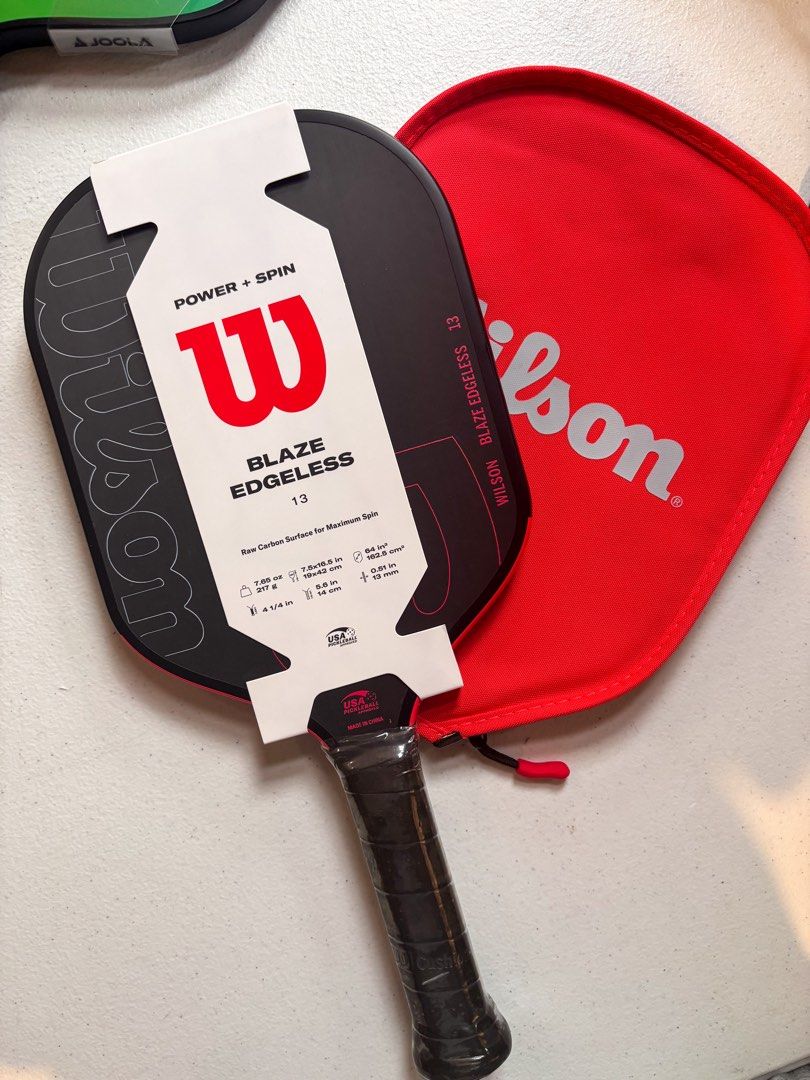 Wilson Blaze Edgeless 13 Pickleball Paddle (Category: Racket and Ball Sports) located in Bacolor. Submitted by tishfinds_ (Listing ID 1466017846, Image 1). Description: - Brand new with store tags still attached over the handle and face - Model: Wilson Blaze Edgeless 13 Pickleball Paddle - Surface: Raw carbon for maximum spin - Weight: 7.65 oz (217 g) - Dimensions: 7.5 x 16.5 inches - Handle & Grip: 5.6-inch handle length with a 4 1/4 inch grip -