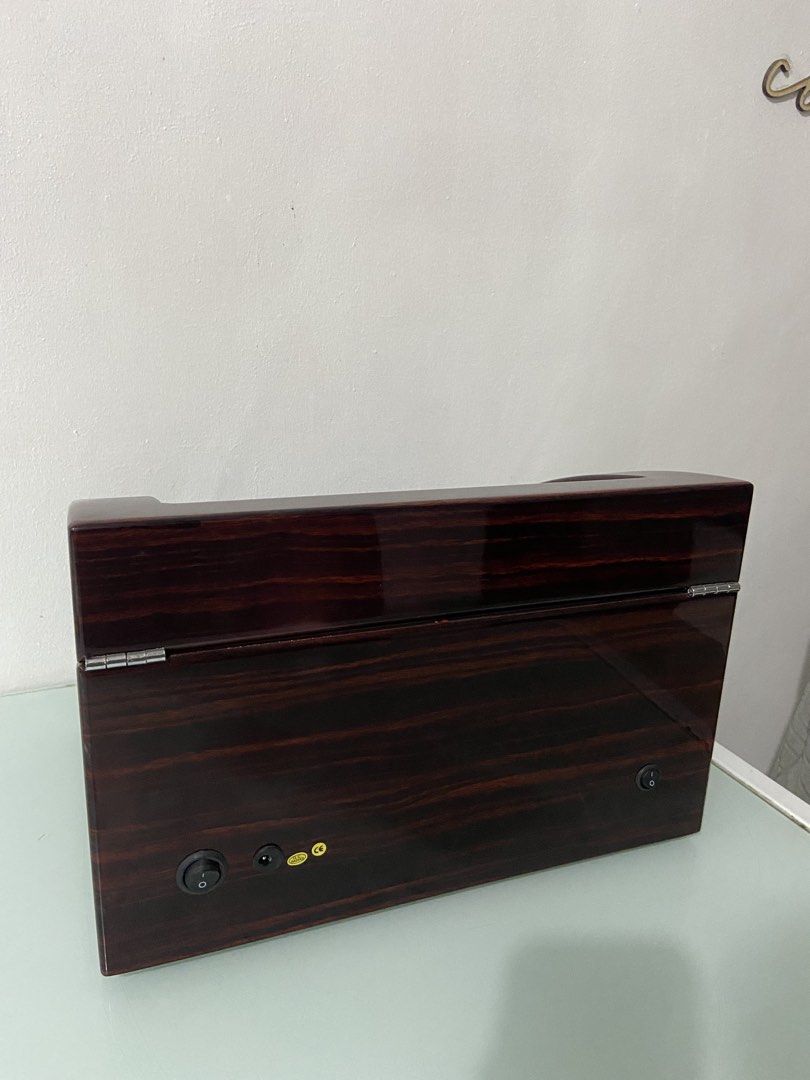 Wooden automatic watch winder box for multiple watches (Category: Men's Watches) located in Makati City. Submitted by mightybear_3ac45c (Listing ID 1465956433, Image 3). Description: - Dark wood grain finish with a sleek glossy coat and tan interior lining - Dual motor modules rotate up to 4 watches simultaneously - Extra storage slots underneath to hold 6 additional watches - Clear glass top display window to showcase your collection - Front key