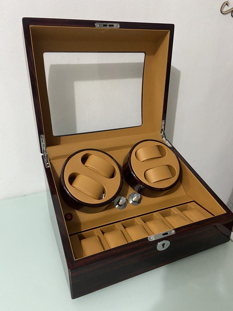 Wooden automatic watch winder box for multiple watches (Category: Men's Watches) located in Makati City. Submitted by mightybear_3ac45c (Listing ID 1465956433, Image 1). Description: - Dark wood grain finish with a sleek glossy coat and tan interior lining - Dual motor modules rotate up to 4 watches simultaneously - Extra storage slots underneath to hold 6 additional watches - Clear glass top display window to showcase your collection - Front key