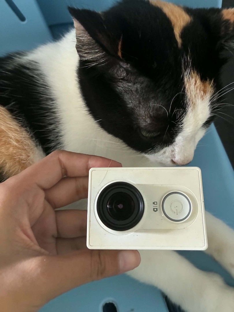Xiaomi Yi Action Camera White (Category: Cameras) located in Bulacan. Submitted by timeless_finds (Listing ID 1465983700, Image 2). Description: White Xiaomi Yi action camera. Power button on front, lens on the side. Ports on the side include USB and micro HDMI. Screw mount on the bottom. Textured pattern on the body. Signs of dust and light dirt on the plastic casing. Works fine. free diving case and charger no sd included.