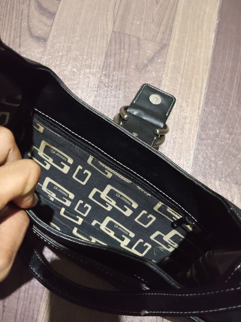 Y2K Guess Black Shoulder Bag with Ring Buckle (Category: Shoulder Bags) located in Mamburao. Submitted by renzocutie (Listing ID 1466127793, Image 3). Description: - Style: Classic Y2K Guess shoulder bag in black - Details: Distinctive double metal logo rings on front flap and stylish white contrast stitching - Interior: Signature Guess monogram fabric lining with a secure zipped pocket - Size: Compact and convenient for carrying daily essentials
