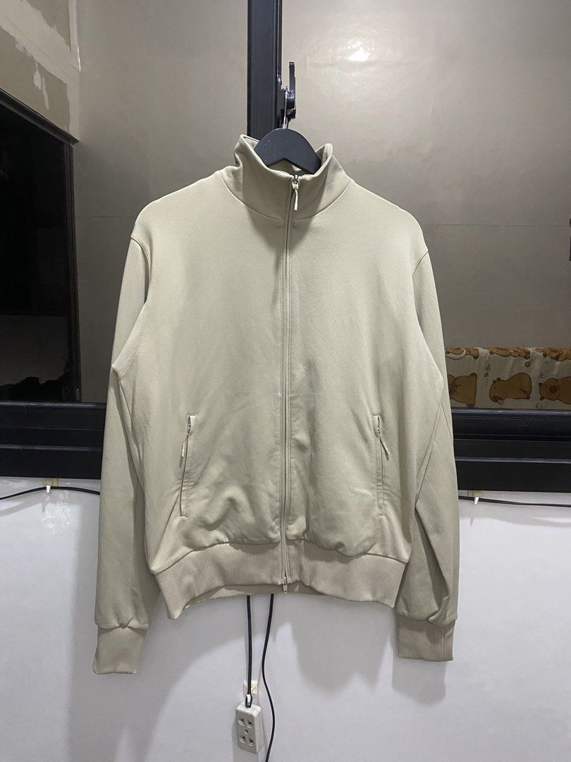 Y-3 Adidas Full Zip Track Jacket Beige Size M (Category: Coats, Jackets and Outerwear) located in Manila. Submitted by hell_market (Listing ID 1466119143, Image 1). Description: Beige Y-3 full zip track jacket by Yohji Yamamoto. Large bright orange Y-3 logo printed across the back. Stand-up collar, ribbed hem, ribbed cuffs, and zippered side pockets. YKK zippers. Made in China. Main material 100% polyamide, ribbing 88% polyamide and 12% elastane,