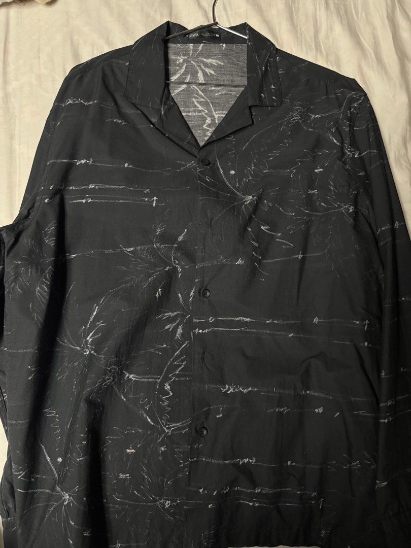Zara Black Graphic Print Button Down Shirt XL (Category: Tshirts & Polo Shirts ) located in Manila. Submitted by seangoart (Listing ID 1466072753, Image 1). Description: - Brand: Zara - Size: XL - Color/Pattern: Black with white sketched palm trees and abstract lines - Style: Open camp collar, button-down, relaxed fit - Origin: Made in Morocco - Material: Lightweight fabric - Condition: Great pre-loved condition with no noticeable flaws.