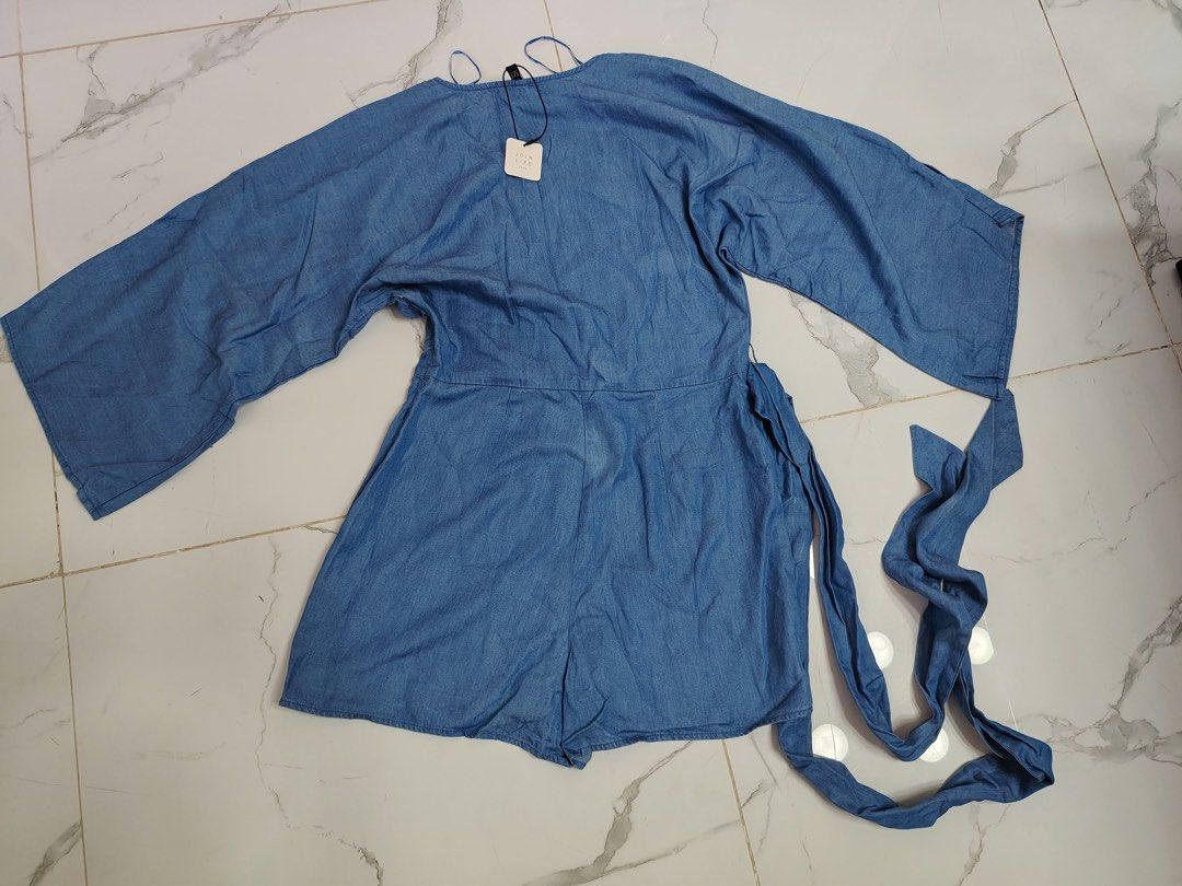 Zara TRF Denim Romper Size M (Category: Rompers) located in Cebu City. Submitted by i_van22 (Listing ID 1466107201, Image 1). Description: Zara TRF denim romper in medium blue wash. V-neck wrap front style with wide flared sleeves and matching waist tie belt. Made in Morocco. Size EUR M, USA M, MEX 28. Original tags still attached..