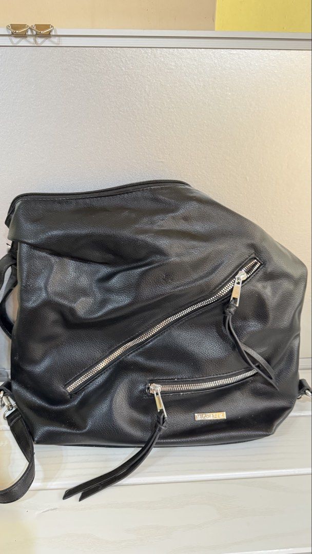 2-way shoulder/back pack (Category: Shoulder Bags) located in Manila. Submitted by oddwolf.aa8f19 (Listing ID 1466185435, Image 1). Description: - Brand: MICHAELA - Color: Classic Black - Style: 2-way versatile design (can be worn as a shoulder bag or backpack) - Material: Soft faux leather with textured finish - Compartments: Multiple exterior zippered pockets for easy organization - Straps: Adjustable straps with sturdy metal hardware - Conditi