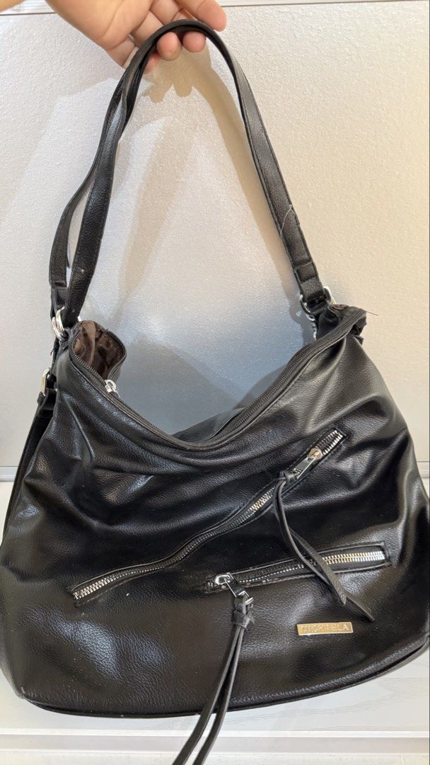 2-way shoulder/back pack (Category: Shoulder Bags) located in Manila. Submitted by oddwolf.aa8f19 (Listing ID 1466185435, Image 2). Description: - Brand: MICHAELA - Color: Classic Black - Style: 2-way versatile design (can be worn as a shoulder bag or backpack) - Material: Soft faux leather with textured finish - Compartments: Multiple exterior zippered pockets for easy organization - Straps: Adjustable straps with sturdy metal hardware - Conditi