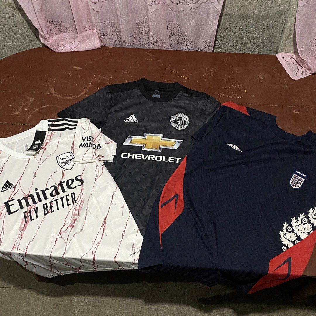 3pcs football jersey (Category: Activewear) located in Iligan City. Submitted by renzreyong66220 (Listing ID 1466249311, Image 1). Description: - Bundle of 3 iconic football jerseys for fans and collectors - 1: Arsenal white away shirt with marble pattern (Brand New with Tags) - 2: Manchester United dark patterned third kit with Chevrolet sponsor - 3: Navy blue England training shirt with red trim and crest detail - Selling as a bundle - grab all