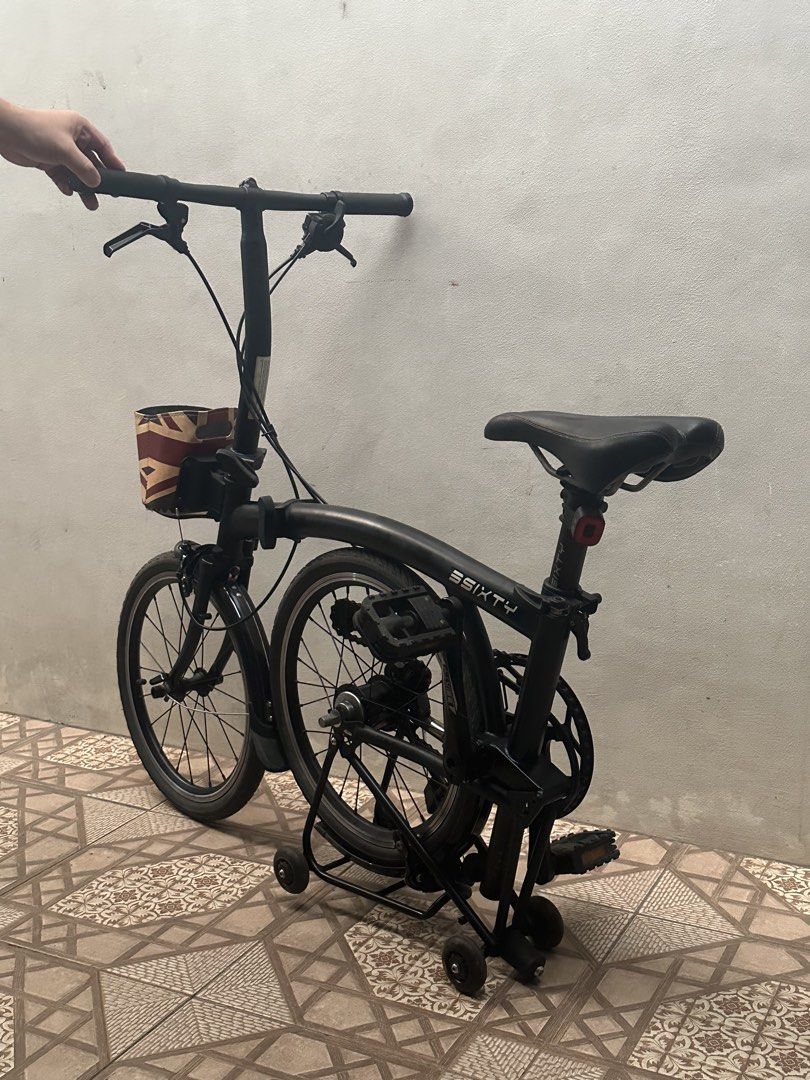 3SIXTY folding bicycle (Category: Bicycles) located in Bulacan. Submitted by savifinds (Listing ID 1466183479, Image 2). Description: - Model: Black 3SIXTY folding bicycle, compact and ideal for city commuting - Condition: Fully functional handlebars, seat, and folding mechanism; tires have thick tread; minor cosmetic scuffs from regular riding - Extras included: Front basket with a stylish Union Jack print and a rear cargo rack equipped with rol