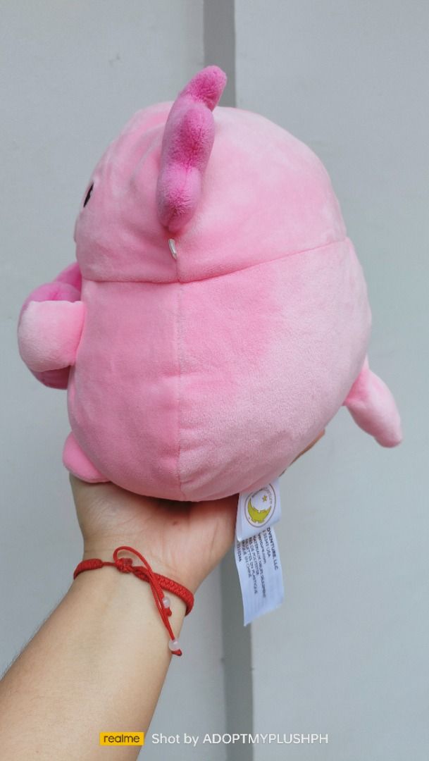 a (Category: Plushies & Soft Toys) located in Taguig. Submitted by adopt.my.plush.ph (Listing ID 1466240032, Image 3). Description: This adorable pink axolotl plush features a cute interactive shaker heart filled with colorful floating glitter on the front..