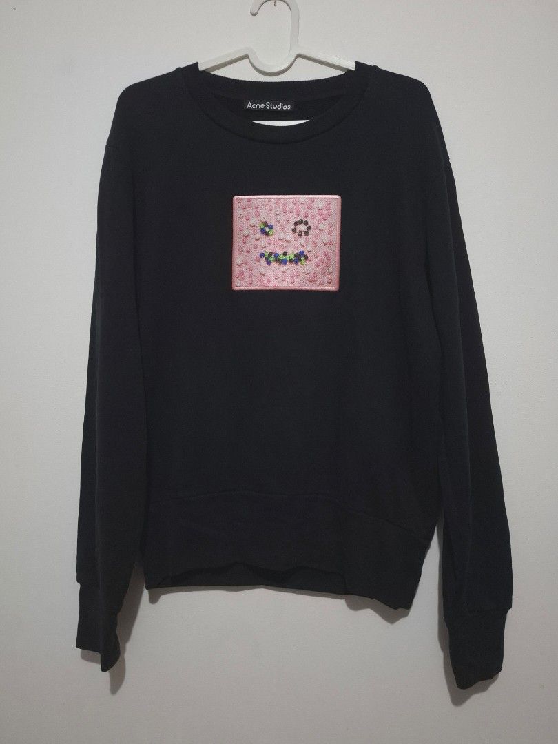 Acne Studios Black Sweatshirt with Pink Beaded Patch (Category: Longsleeves) located in Mandaue City. Submitted by lootr (Listing ID 1466276775, Image 1). Description: - Brand: Acne Studios - Style: Black crewneck sweatshirt with classic minimalist fit - Details: Signature square pink chest patch with colorful beaded detailing - Material: 100% cotton shell with ultra-soft fleece lining inside - Comfort: Ribbed collar, cuffs, and hem for extra war