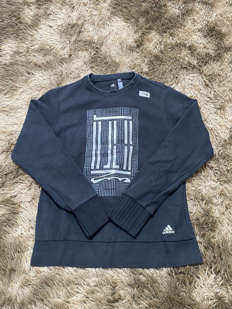 Adidas Black Graphic Sweatshirt (Category: Coats, Jackets and Outerwear) located in Cagayan de Oro. Submitted by sepamorash53558 (Listing ID 1466328881, Image 1). Description: - Brand: Adidas - Style: Crewneck sweatshirt - Color: Black with large grey geometric graphic on chest and small logo near hem - Size: A/XS - Material: 69% cotton, 31% recycled polyester - Features: Ribbed cuffs and collar - Origin: Made in China - Condition: Excellent.