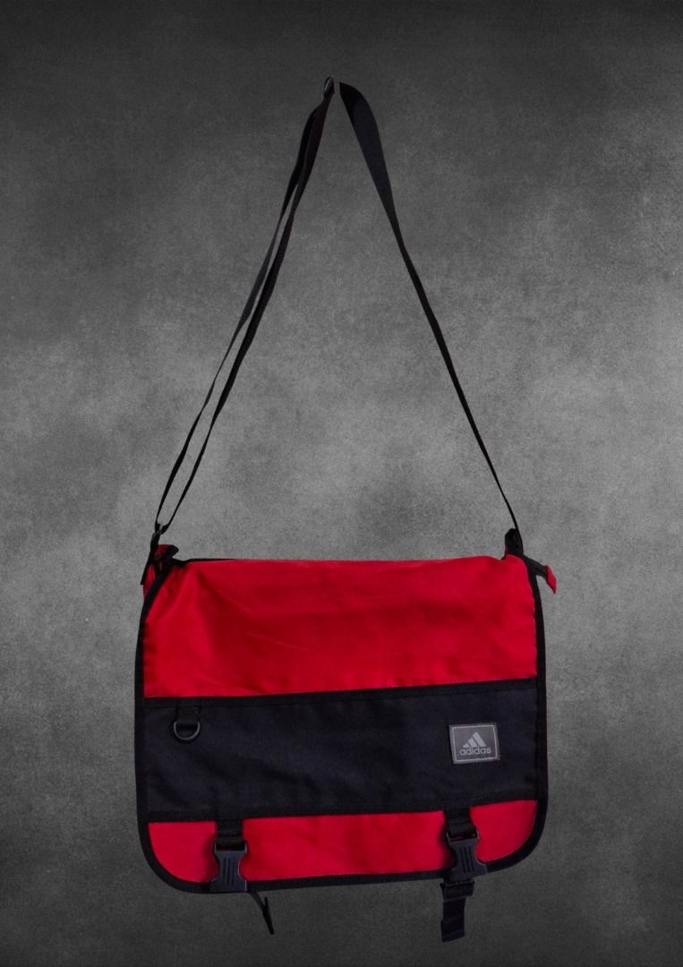 Adidas Red and Black Sling Bag (Category: Sling Bags) located in Bulacan. Submitted by kei.collections (Listing ID 1466299514, Image 1). Description: - Brand: Adidas - Color: Red and black - Color Rate: 9.8/10 - Material: Durable canvas - Strap: Adjustable shoulder strap - Closure: Sturdy plastic buckles on front flap - Pockets: Exterior zippered pocket on back flap - Details: Stitched fabric patch logo and small D-ring on front - Condition: 10/1
