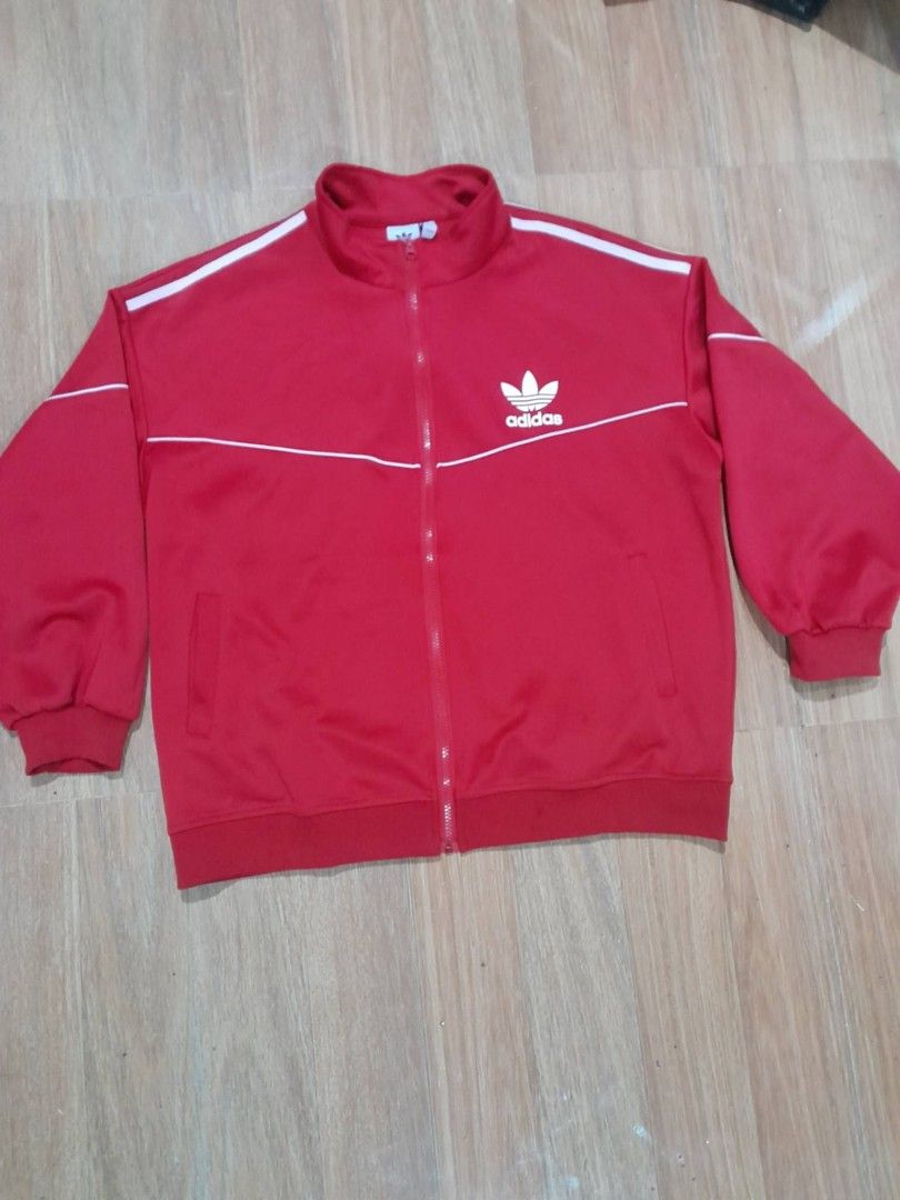 Adidas Red Track Jacket Size M (Category: Coats, Jackets and Outerwear) located in Calamba. Submitted by ysabellascloset17 (Listing ID 1466291687, Image 1). Description: - Brand: Adidas - Color: Bright red with white stripes - Logo: Iconic Trefoil logo on the chest - Design: Full zip front, stand-up collar, ribbed cuffs and hem - Size: Medium (M) 25 x 26.5 - Condition: Clean stitching inside and out - Style: Comfortable everyday sporty layer.