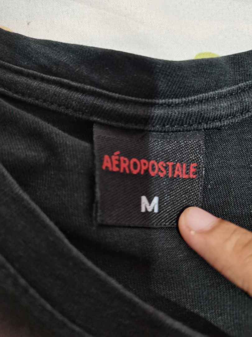 Aeropostale 1987 Black T-shirt Medium (Category: Tshirts & Polo Shirts ) located in Dipolog. Submitted by true.brclo_thing (Listing ID 1466264152, Image 2). Description: - Brand: Aeropostale - Color: Black - Size: Medium - Design: White cursive logo text with '1987' print on chest and red tag near bottom hem - Fit/Style: Short sleeves, crew neck, comfortable everyday cotton material .