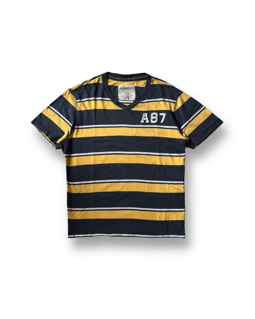 AEROSPORTALE (Category: Tshirts & Polo Shirts ) located in Davao. Submitted by kelsocool (Listing ID 1466256573, Image 1). Description: Aéropostale A87 Striped V-Neck Tee Dimes (inch): 24 - length 20 - width 8 - sleeve color rate: 8/10 good condition issue - small stains Model: 5’5 ft/ 54 kg Description: Y2K-era bold horizontal stripe V-neck tee featuring stitched A87 chest applique..