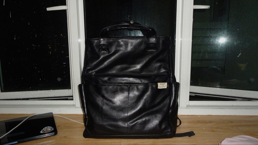 Anello ARLO Black Leather Backpack (ATB4525) (Category: Backpacks) located in Manila. Submitted by julianna_dm (Listing ID 1466277959, Image 3). Description: Anello backpack in black faux leather. dual top handles with snap button strap. front zippered pocket and open slip pockets on the sides. woven fabric brand patch stitched on the front lower pocket. spacious main compartment. adjustable back straps attached at the bottom. soft, slouchy struc