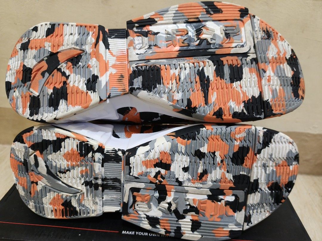Anta Player 2.0 (Category: Sneakers) located in Taguig. Submitted by skyflakes007 (Listing ID 1466304324, Image 3). Description: - Brand: Anta Player 2.0 Basketball Sneakers -Authentic -Size US 8 -Good condition - Colorway: Orange, black, and grey camo pattern - Design: High-top knit upper with orange synthetic accents and chunky white midsole - Details: Speckled rope laces with white lace tubes, tongue pull tabs, and matching camo traction soles