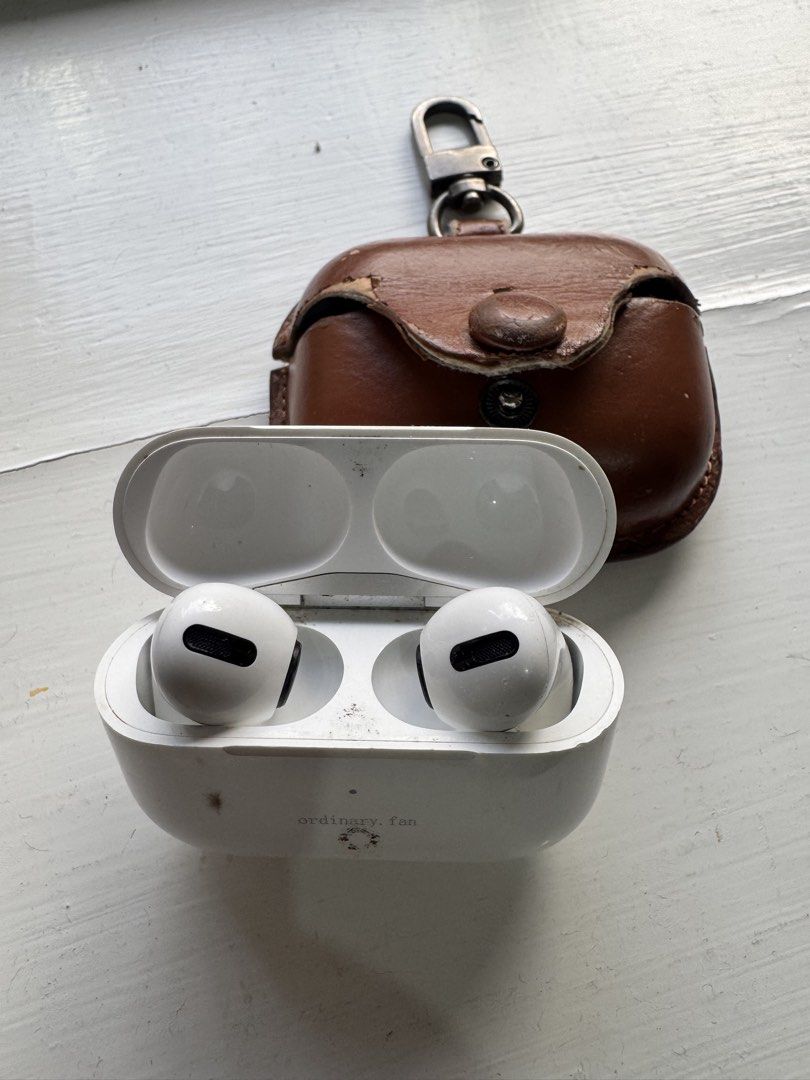 Apple AirPods Pro with leather case （分類：耳機）位於 Hong Kong。 由 dcdhiren1986 提交（商品編號 1466219135，圖片 1）。簡介： Apple AirPods Pro wireless earbuds with charging case. Includes a worn brown leather protective case with key ring clip. Charging case shows minor dirt marks and scuffs from daily use. Earbuds are white with black mesh vents. Working very well, earbuds holds more than 4 hours in single charge. Can meet in central, Kowloontong, Tuen mun , Yuen long