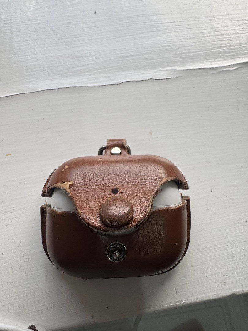 Apple AirPods Pro with leather case （分類：耳機）位於 Hong Kong。 由 dcdhiren1986 提交（商品編號 1466219135，圖片 3）。簡介： Apple AirPods Pro wireless earbuds with charging case. Includes a worn brown leather protective case with key ring clip. Charging case shows minor dirt marks and scuffs from daily use. Earbuds are white with black mesh vents. Working very well, earbuds holds more than 4 hours in single charge. Can meet in central, Kowloontong, Tuen mun , Yuen long