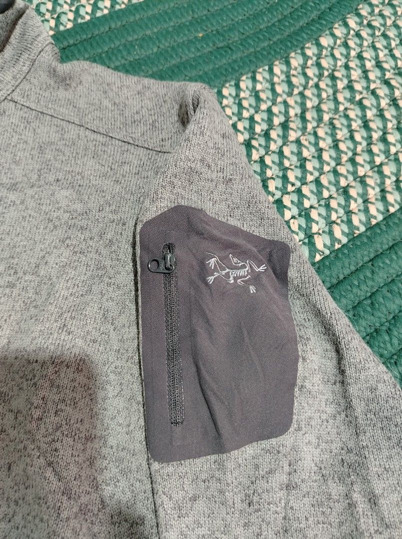 Arc'teryx Covert 1/2 Zip M Grey Fleece Pullover (Category: Coats, Jackets and Outerwear) located in Lucena. Submitted by thrifteditem (Listing ID 1466295610, Image 3). Description: - Brand: Arc'teryx AUTHENTIC - Model: Covert 1/2 Zip Fleece Pullover - Color: Grey Heather - Size: Men's Medium (M) - Details: Half-zip front, high collar, soft fleece interior/exterior, and left sleeve zippered pocket with embroidered fossil logo - Certification: Fair