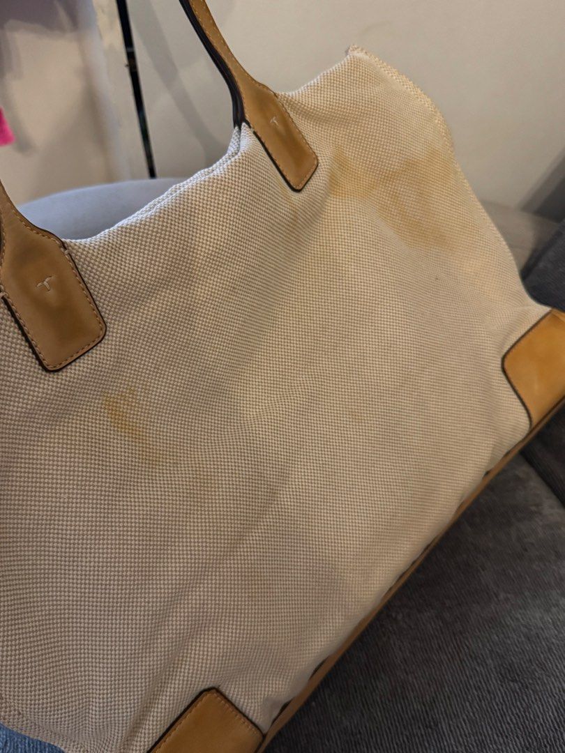 Auth Tory Burch Tote Bag (Category: Tote Bags) located in Pasay City. Submitted by shop.stylestaple (Listing ID 1466212173, Image 3). Description: - Tory Burch Canvas Tote Bag Tan Cream - Brand: Tory Burch - Style: Canvas and leather tote bag - Color: Cream canvas with tan leather trim and handles - Design: Large cut-out double T logo on the front, structured leather base - Condition: Pre-loved with noticeable canvas discoloration and staining (m