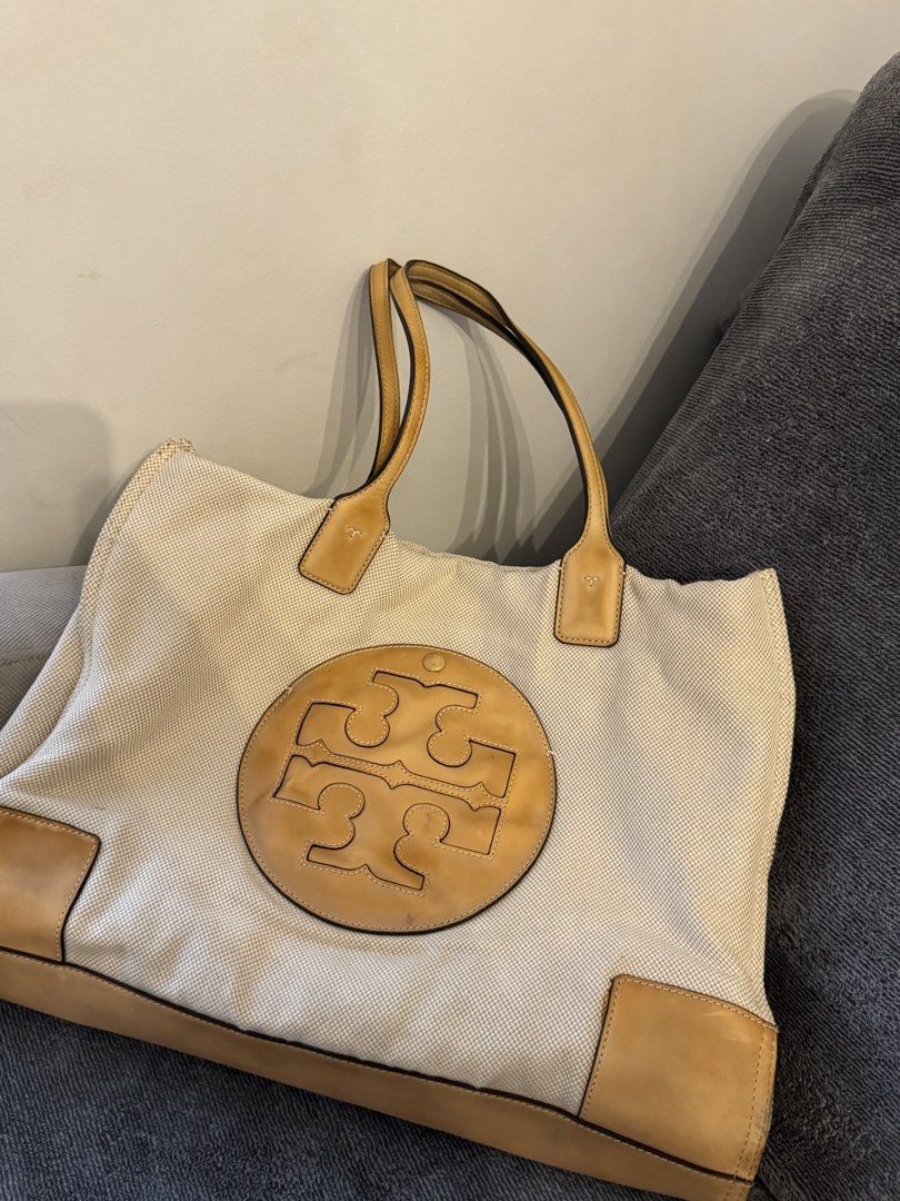 Auth Tory Burch Tote Bag (Category: Tote Bags) located in Pasay City. Submitted by shop.stylestaple (Listing ID 1466212173, Image 1). Description: - Tory Burch Canvas Tote Bag Tan Cream - Brand: Tory Burch - Style: Canvas and leather tote bag - Color: Cream canvas with tan leather trim and handles - Design: Large cut-out double T logo on the front, structured leather base - Condition: Pre-loved with noticeable canvas discoloration and staining (m