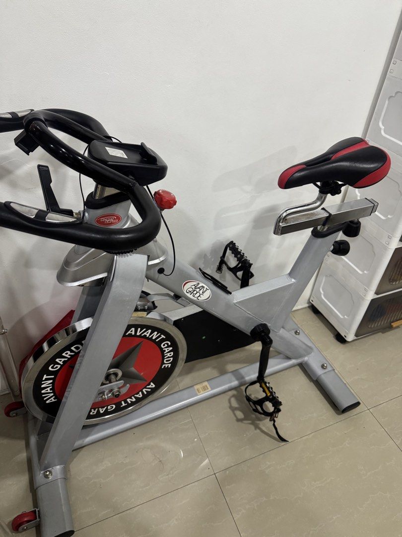 Avant Garde Indoor Exercise Bike (Category: Cardio & Fitness Machines) located in Manila. Submitted by sharry24 (Listing ID 1466157117, Image 3). Description: - Brand: Avant Garde indoor stationary bike - Heavy front flywheel with striking red and black graphic plate - Adjustable handlebars with built-in device holder and easy-reach resistance knob - Comfortable padded black and red seat on a chrome slider - Secure pedals featuring toe cages and 