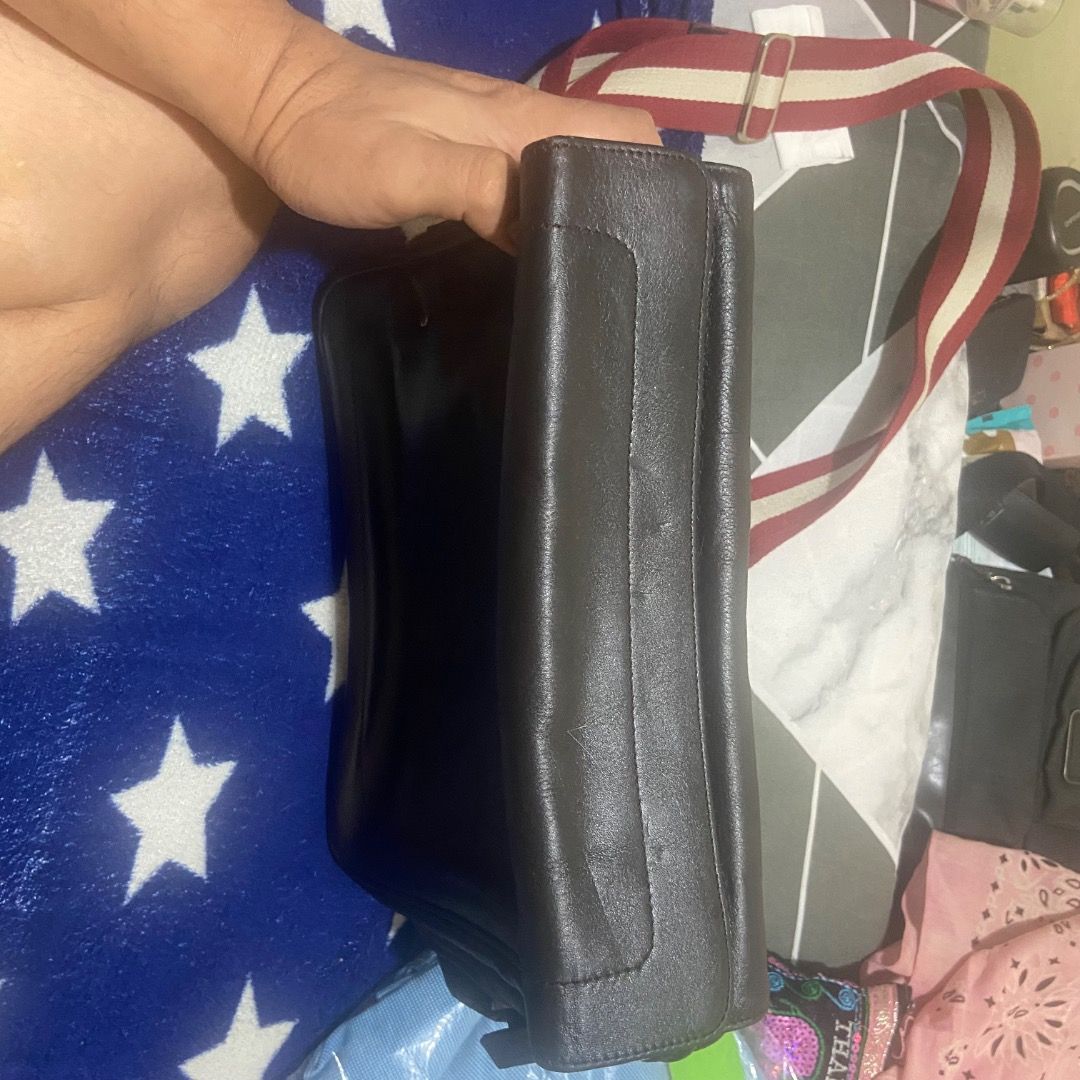 Bally Black Leather Messenger Bag with Red Stripe Strap (Category: Sling Bags) located in Paranaque City. Submitted by vincechong0813 (Listing ID 1466171541, Image 3). Description: - Brand: Bally - Color & Material: Classic black, genuine leather - Design: Structured flap top with secure zip closure underneath - Strap: Adjustable canvas strap featuring the iconic red and white Bally stripe - Hardware: Silver-tone accents with branded zipper pull 