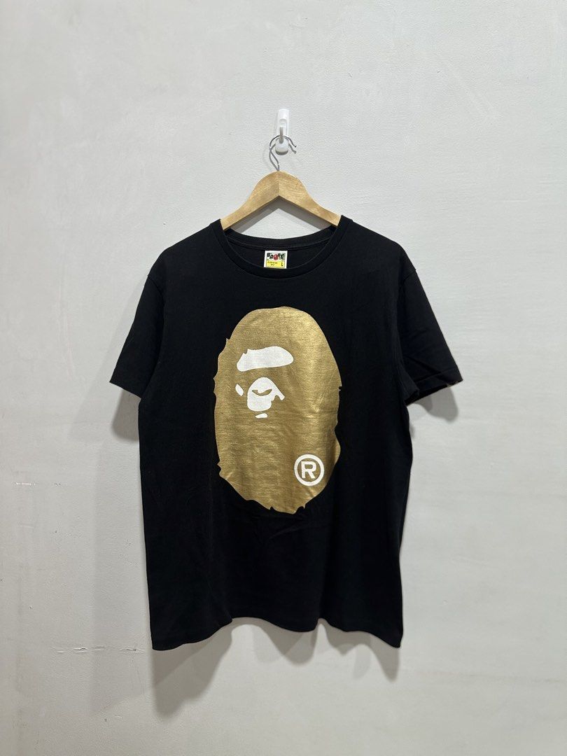 BAPE Big Ape Head Gold Mirror Tee Black L (Authentic) (Category: Tshirts & Polo Shirts ) located in Manila. Submitted by ylsrarities (Listing ID 1466332949, Image 1). Description: Pre owned with normal signs of age and wear. The metallic gold graphics show natural surface texture and signs of aging consistent with wear. Black body remains in good overall condition with no major holes or tears noted. • Metallic gold Big Ape Head front graphic • La