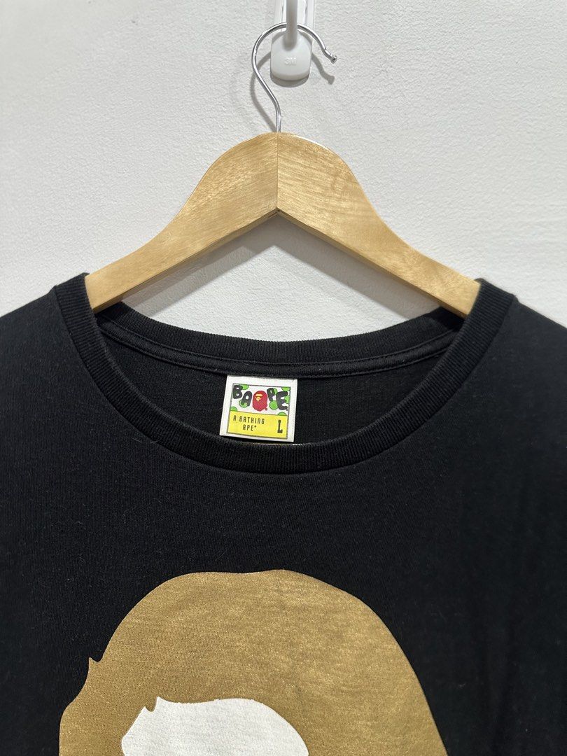 BAPE Big Ape Head Gold Mirror Tee Black L (Authentic) (Category: Tshirts & Polo Shirts ) located in Manila. Submitted by ylsrarities (Listing ID 1466332949, Image 3). Description: Pre owned with normal signs of age and wear. The metallic gold graphics show natural surface texture and signs of aging consistent with wear. Black body remains in good overall condition with no major holes or tears noted. • Metallic gold Big Ape Head front graphic • La