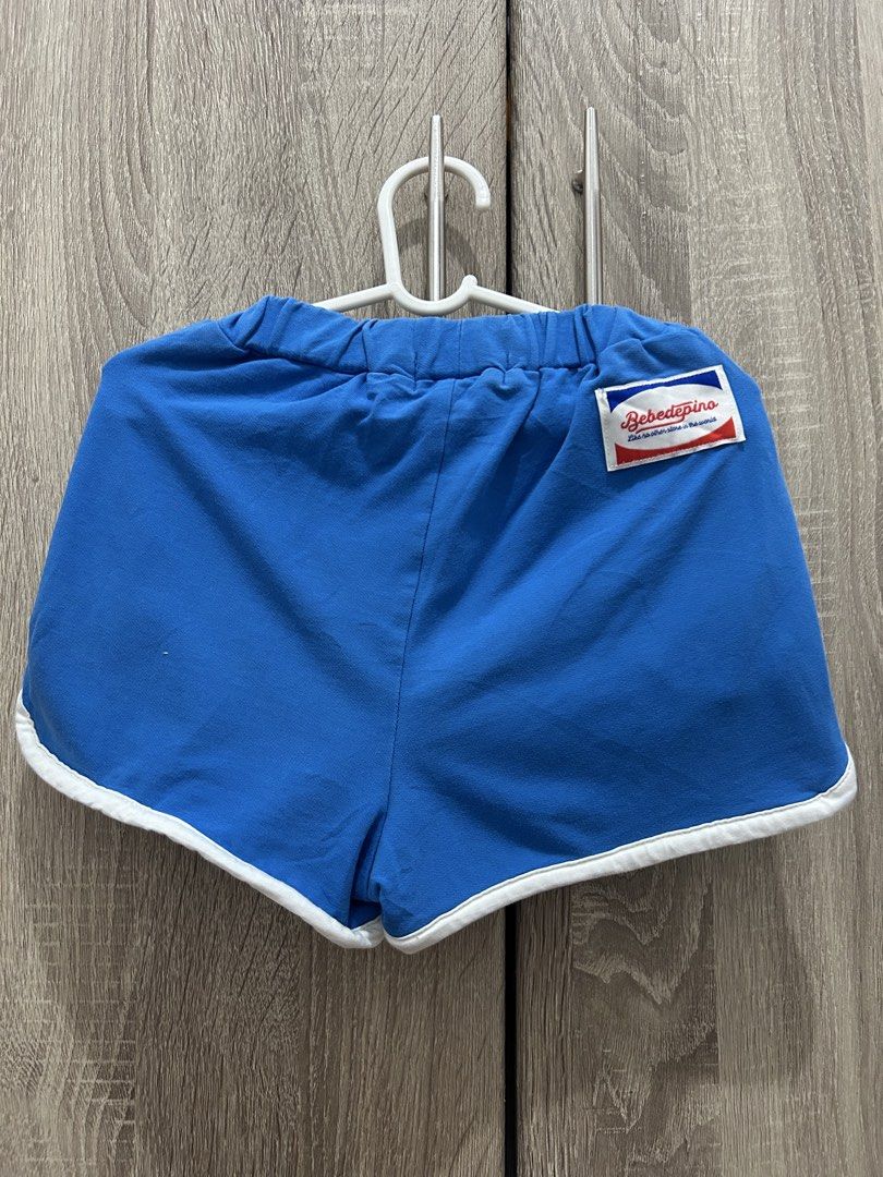 Bebe De Pino Blue Shorts with Jollibee Patch (Category: Babies & Kids Fashion) located in Makati City. Submitted by michellecollado07 (Listing ID 1466313326, Image 3). Description: Bright blue toddler shorts from Bebe De Pino. Elastic waistband with adjustable white drawstring. White piping trim along the sides and hem. Cute blue bunny character patch on the front pocket plus a red 'B' patch. Signature Bebe De Pino logo patch stitched on the back