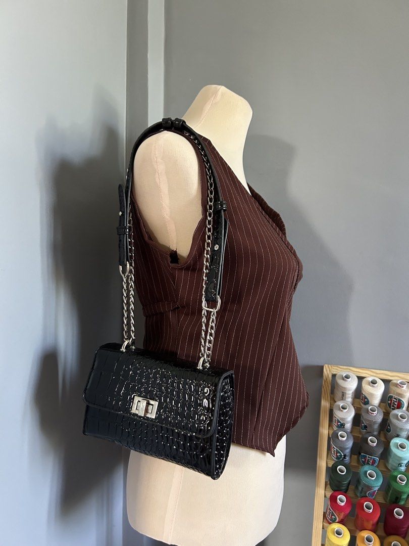Black Croc Embossed Patent Leather Shoulder Bag with Silver Chains (Category: Shoulder Bags) located in Banaybanay. Submitted by rethread.co (Listing ID 1466188733, Image 2). Description: - Style: Black patent leather shoulder bag with a glossy croc-embossed texture - Straps: Silver chain mixed with comfortable black leather shoulder pads - Closure: Secure metal turn-lock on the front flap - Interior: Clean lining with a structured rectangular sh