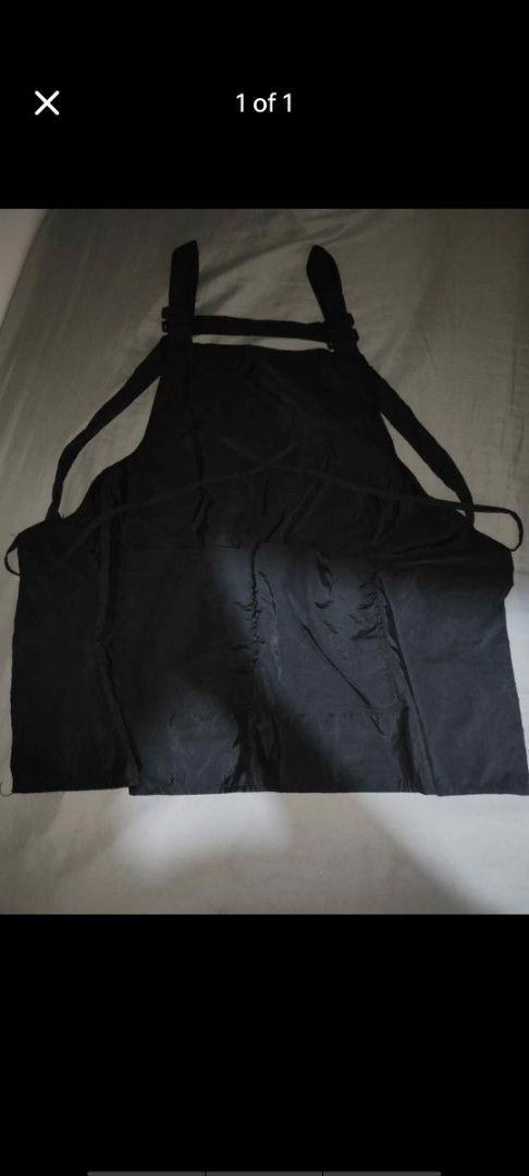 Black cross-back utility apron with pockets (Category: Sleeveless) located in Manila. Submitted by billythekid05 (Listing ID 1466278581, Image 1). Description: - Color: Solid black - Design: Cross-back adjustable straps with long, easy-wrap waist ties - Storage: Large front pockets for daily essentials - Material: Sturdy, durable fabric construction - Ideal for: Cooking, barista work, crafting, and everyday tasks.