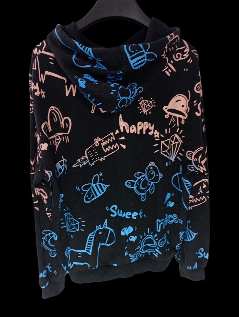 Black Graffiti Print Hoodie Size Large (Category: Hoodies) located in Rodriguez. Submitted by enzo.tv (Listing ID 1466326139, Image 3). Description: Black hoodie covered in colorful doodle prints including unicorns, diamonds, and bears. Drawstring hood and ribbed cuffs. Length measures 19.5 inches, width is 17 inches. Overall good shape, though one print design has some distortion. Comfortable everyday wear with plenty of personality..
