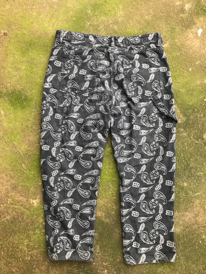 Black Paisley Print Denim Carpenter Pants (Category: Jeans) located in Jimenez. Submitted by onlythrifty_ (Listing ID 1466213286, Image 2). Description: - Color & Pattern: Dark grey with an all-over white paisley print - Fit: Relaxed straight leg for maximum comfort - Material: Heavyweight, durable cotton with crisp print details - Features: Classic carpenter style with functional utility pockets on sides and back - Closure: Button fly Waist- 32 