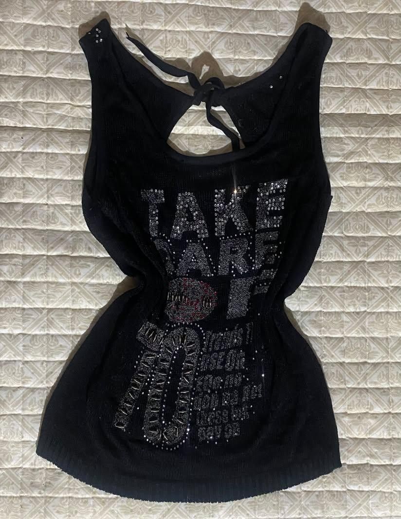 Black Rhinestone Y2K Tank Top (Category: Sleeveless) located in Pagadian. Submitted by kahtlopez47867 (Listing ID 1466278393, Image 2). Description: - Style: Y2K black knit tank top - Details: 'Take Care 70' rhinestone graphics on front - Back Design: Keyhole cutout with adjustable tie strings - Accents: Rhinestones on the straps - Fabric: Soft with slight stretch - Best for: Parties or everyday streetwear.