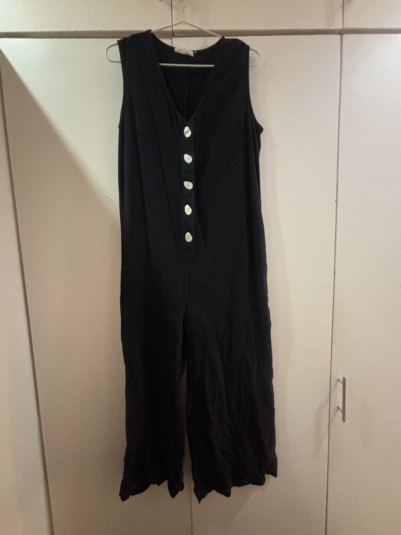 Black sleeveless button-front jumpsuit (Category: Jumpsuits) located in Las Pinas. Submitted by misg0905 (Listing ID 1466243429, Image 1). Description: - Color: Black with contrasting white buttons - Design: Sleeveless, deep V-neckline, center front button placket - Fit: Relaxed fit with a trendy wide-leg crop cut - Material: Lightweight and breathable fabric - Style Tip: Perfect for warm weather; pair with sandals or sneakers for an effortless l