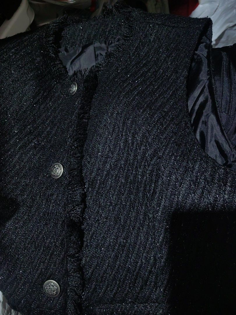 Black Tweed Sleeveless blazer (Category: Sleeveless) located in Donsol. Submitted by saksthriftavenuebyluckymaria8 (Listing ID 1466259010, Image 2). Description: - Style: Black tweed sleeveless vest with subtle metallic threading - Details: Fringe trim on neckline, placket, and pockets with ornate silver-tone metal buttons - Features: Fully lined interior, two front functional pockets - Size: Free Size (F) - Material: Polyester and cotton blend -