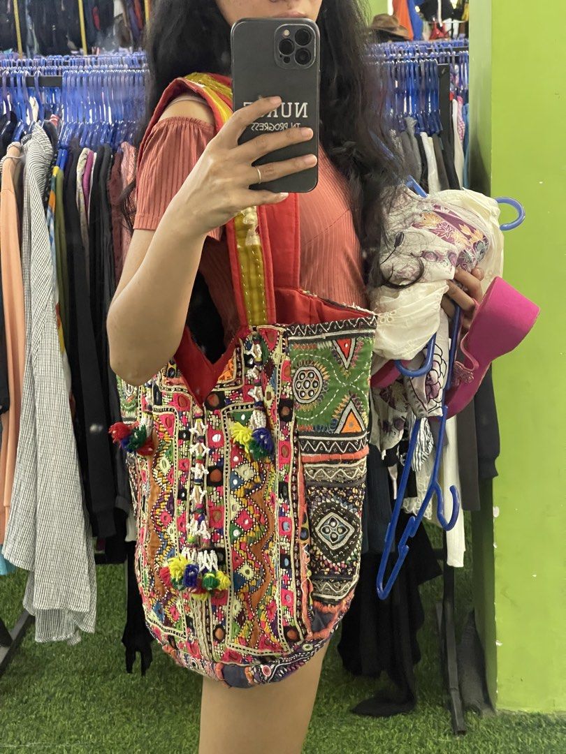 Boho embroidered patchwork tote bag with colorful tassels (Category: Tote Bags) located in La Trinidad. Submitted by potatothriftlip (Listing ID 1466236957, Image 3). Description: - Style: Vibrant handmade tote bag with intricate patchwork and embroidery - Details: Colorful panels in pink, green, yellow, and purple with traditional mirror work - Accents: Hanging beaded tassels and playful pom-poms on the front - Straps: Sturdy red fabric straps f