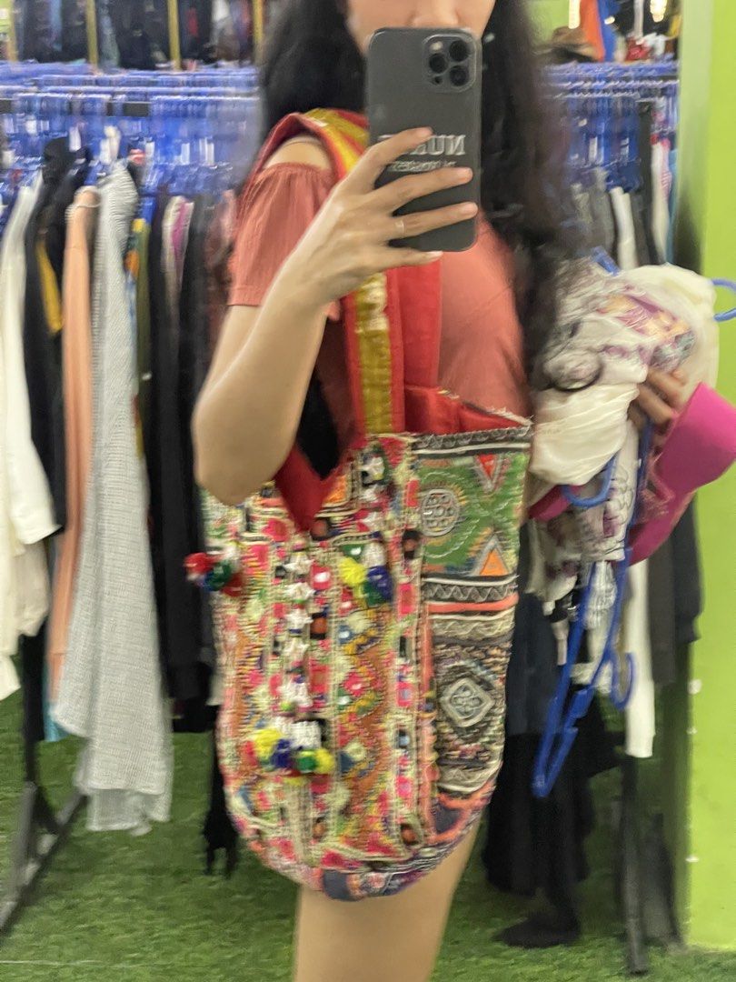 Boho embroidered patchwork tote bag with colorful tassels (Category: Tote Bags) located in La Trinidad. Submitted by potatothriftlip (Listing ID 1466236957, Image 2). Description: - Style: Vibrant handmade tote bag with intricate patchwork and embroidery - Details: Colorful panels in pink, green, yellow, and purple with traditional mirror work - Accents: Hanging beaded tassels and playful pom-poms on the front - Straps: Sturdy red fabric straps f