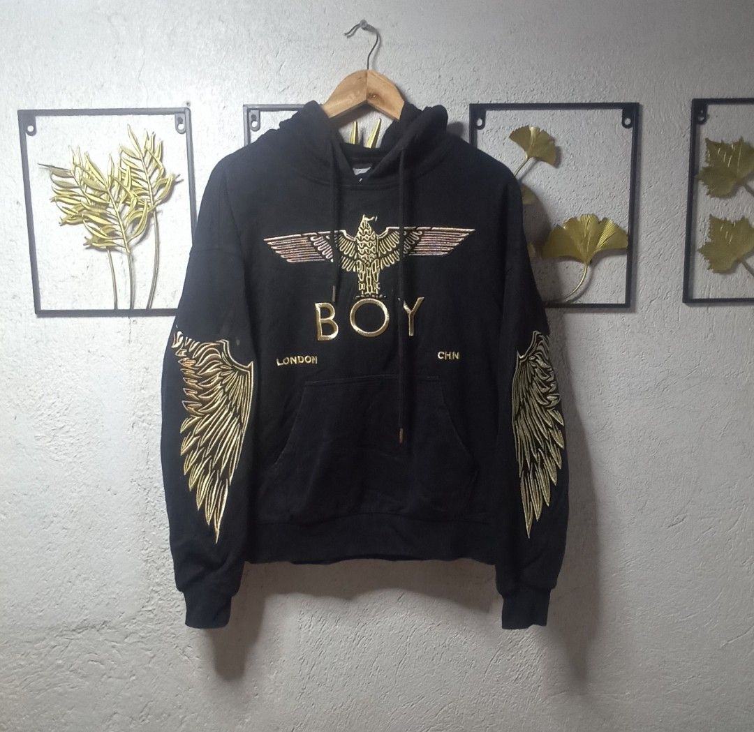 Boy London Hoodie (Category: Coats, Jackets and Outerwear) located in Kawit. Submitted by deidzdzn (Listing ID 1466216809, Image 2). Description: - Brand: Boy London - Color: Black with striking gold graphic embroidery on chest and sleeves - Size: Tagged XS, but fits like a comfortable Medium - Dimensions: Width 23" x Length 24" - Features: Front kangaroo pocket, drawstring hood - Material: Heavyweight, premium quality fabric.
