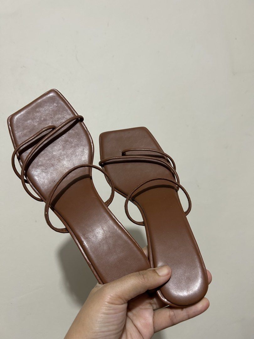 Brown Square Toe Strappy Kitten Heel Sandals (Category: Heels) located in Makati City. Submitted by charavelasco (Listing ID 1466238350, Image 1). Description: - Color: Brown with contrasting black sole - Design: Trendy square toe with delicate tubular straps - Heel: Sleek and comfortable thin kitten heel - Style: Easy slip-on design for the front and ankle - Condition: Clean finish with minimal wear visible.