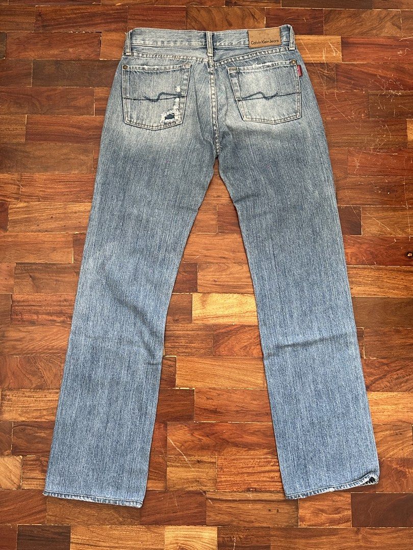 Calvin Klein Jeans Light Wash Denim (Category: Jeans) located in Cainta. Submitted by buy.preloved (Listing ID 1466192517, Image 3). Description: - Brand: Calvin Klein - Size W 29 - Wash: Light wash denim - Cut: Classic straight or slightly flared leg - Style: Vintage 90s aesthetic - Details: Distressed accents near right front and back pockets - Hardware: Zip fly with durable brass hardware - Special Features: Branded buttons and unique red inte
