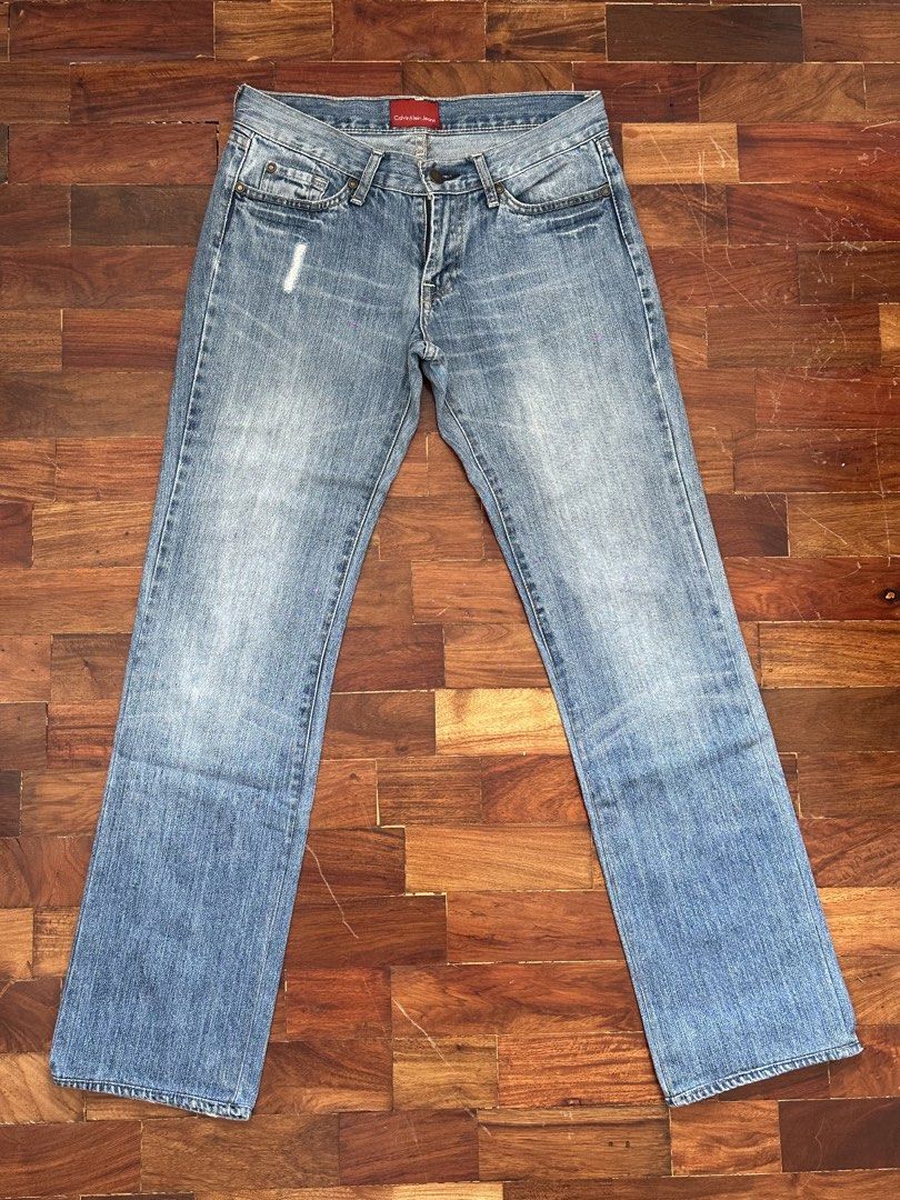 Calvin Klein Jeans Light Wash Denim (Category: Jeans) located in Cainta. Submitted by buy.preloved (Listing ID 1466192517, Image 1). Description: - Brand: Calvin Klein - Size W 29 - Wash: Light wash denim - Cut: Classic straight or slightly flared leg - Style: Vintage 90s aesthetic - Details: Distressed accents near right front and back pockets - Hardware: Zip fly with durable brass hardware - Special Features: Branded buttons and unique red inte
